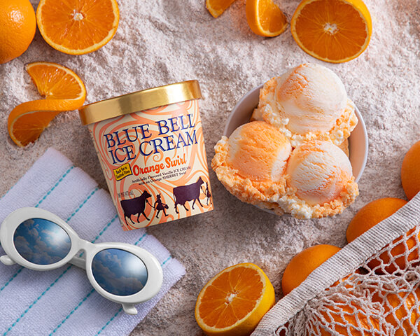 Blue Bell Ice Cream Orange Swirl in pint on beach scene